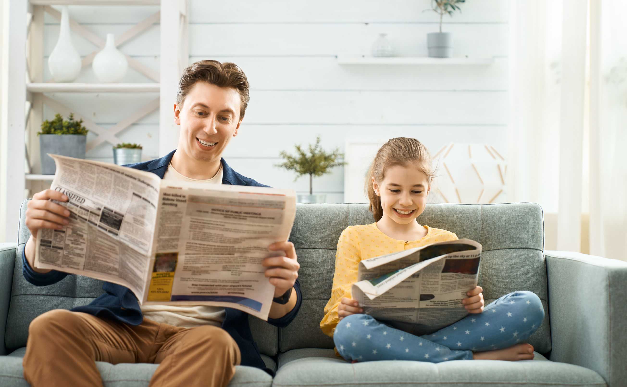 Dad and daughter reading newspaper