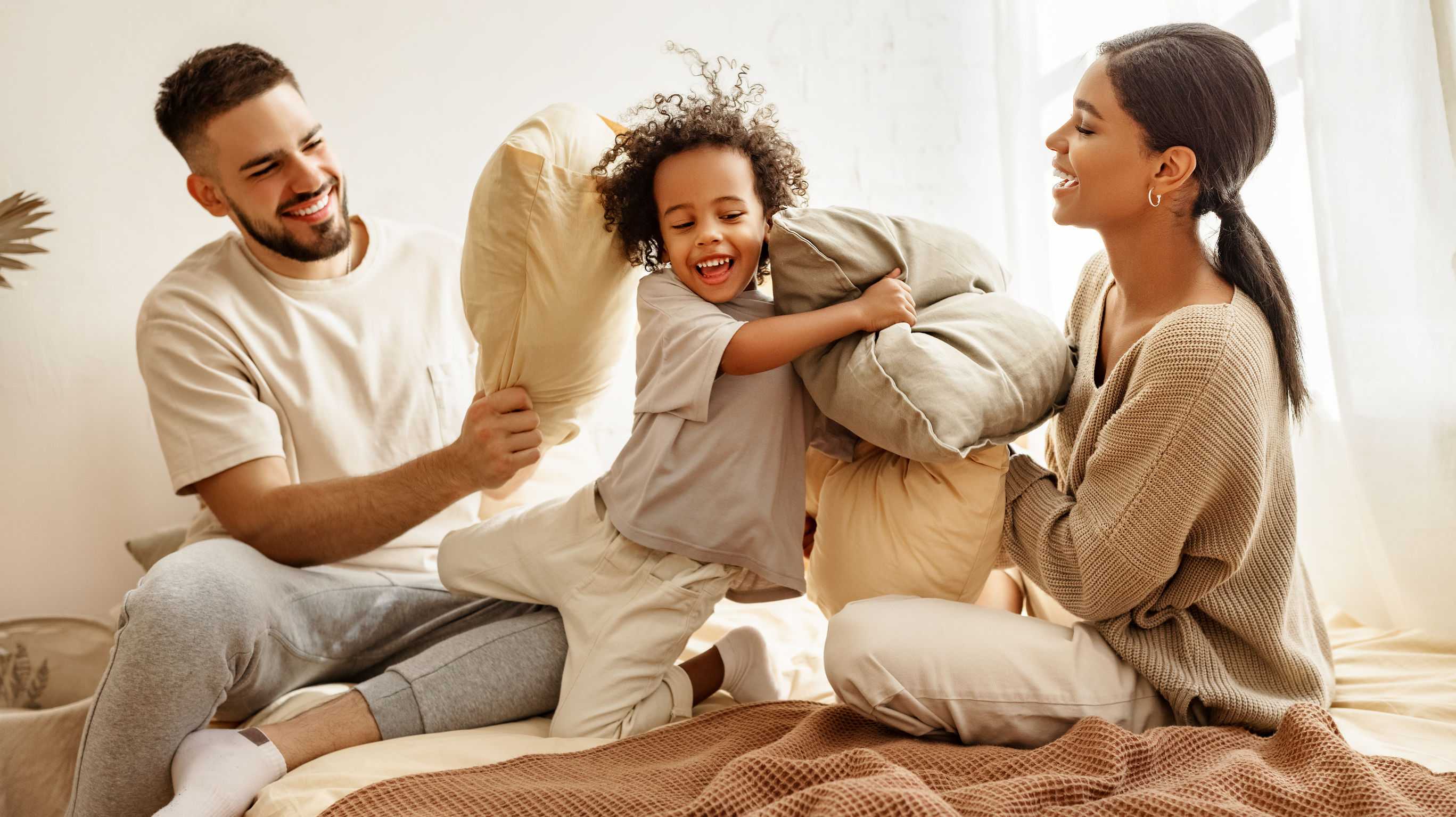 Family laughing during pillow fight