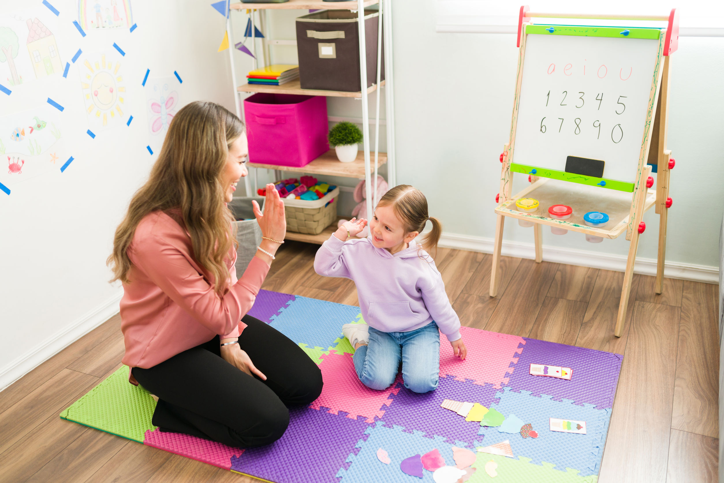 Teacher giving child high-five showing she is proud
